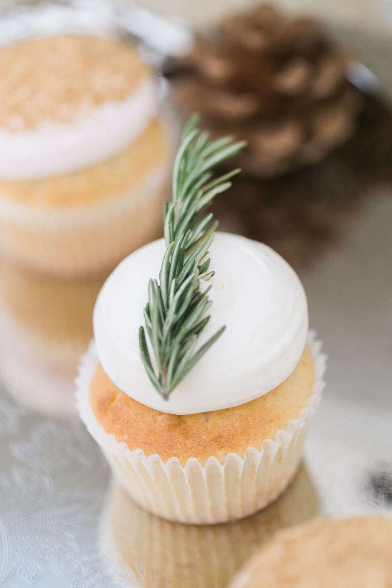 vanilla cupcake with frosting and rosemary sprig