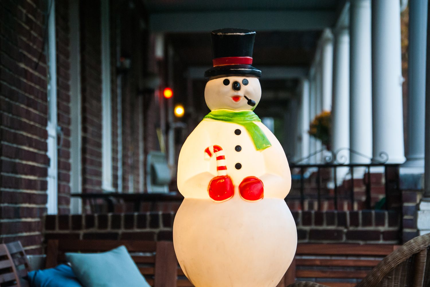A vintage christmas decoration that is lighted sitting on a row home porch