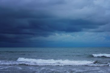 Waves on a beach under cloudy skies