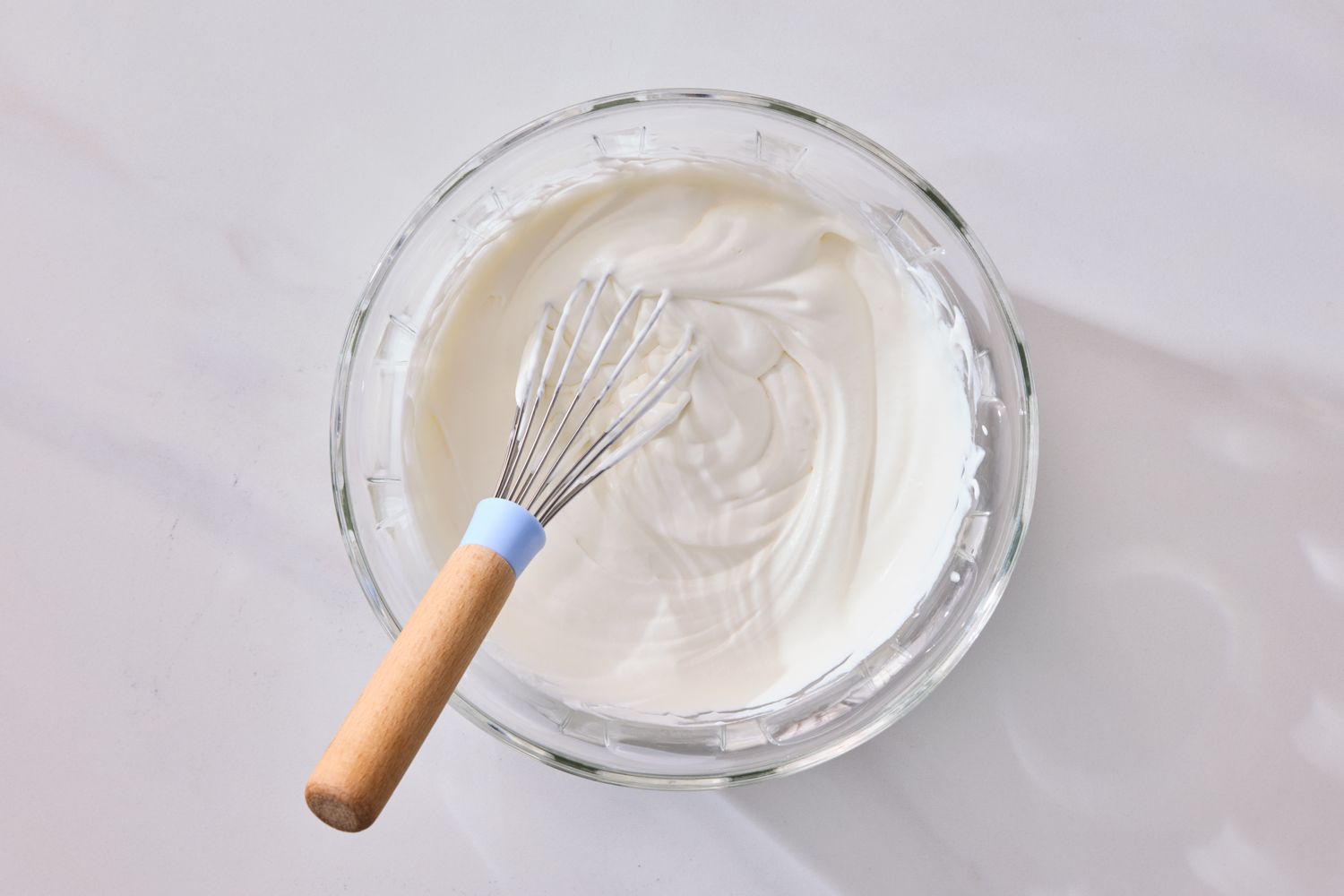 A bowl of whipped cream with a whisk