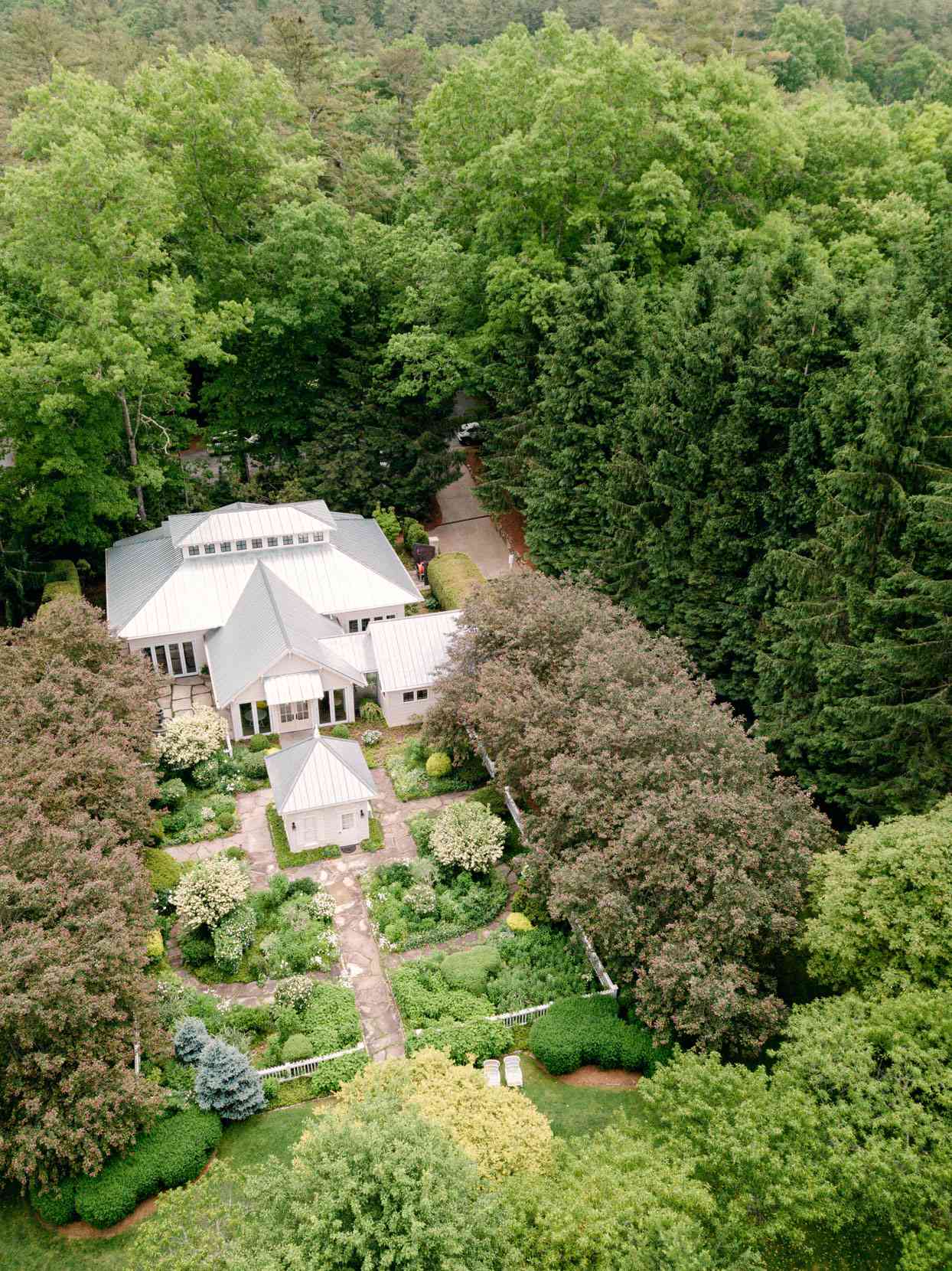 large white building wedding venue surrounded by trees