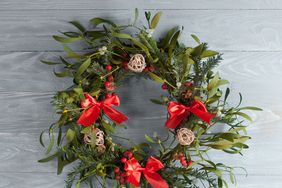 Christmas wreath with mistletoe on wood board