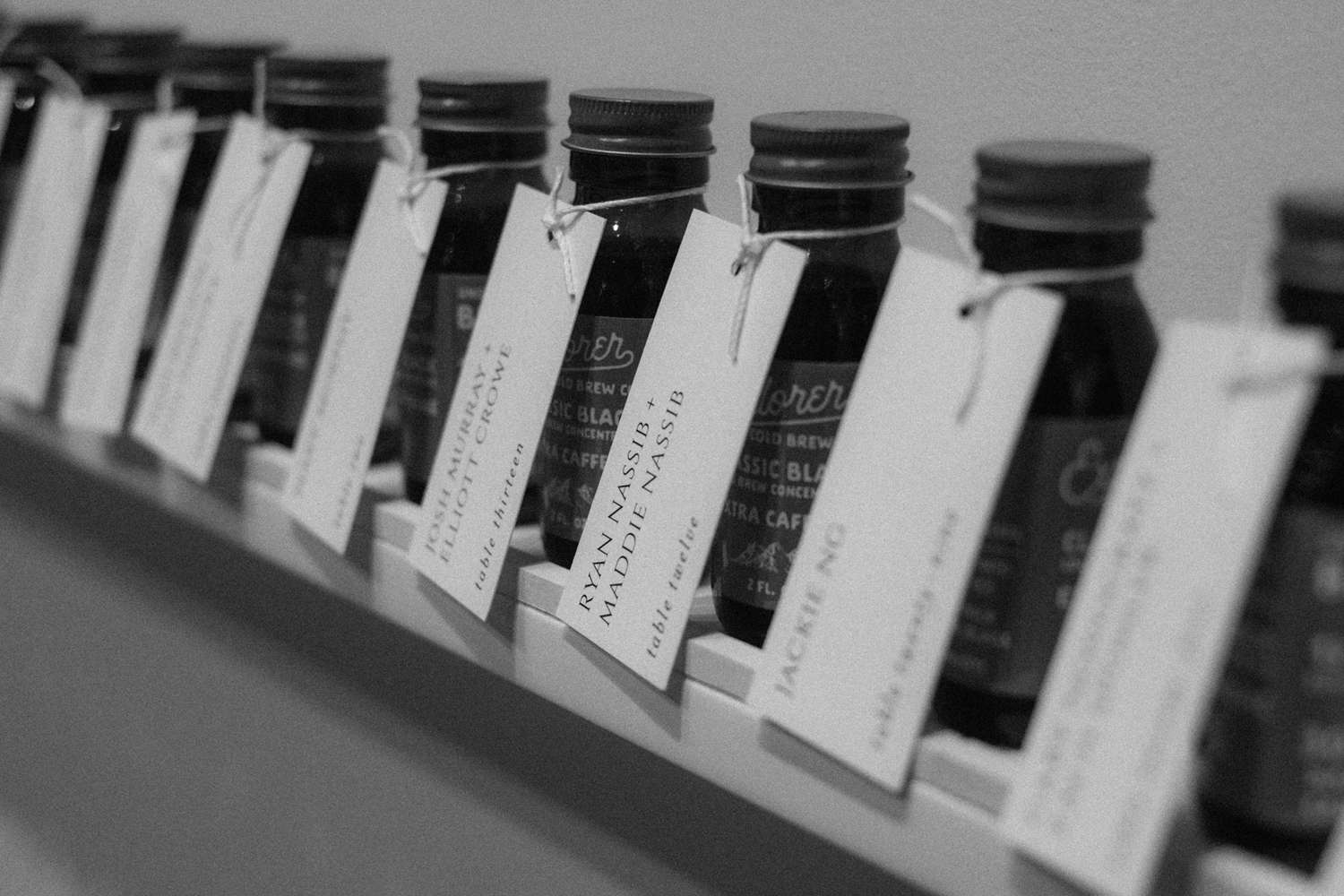 wedding escort cards tied to bottles of coffee