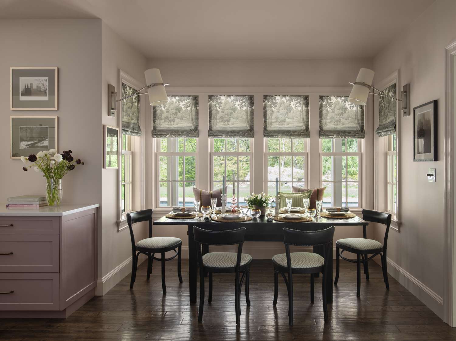 Dining room with a table set for a meal under large windows