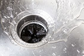 Water flowing into a sink drain with a garbage disposal