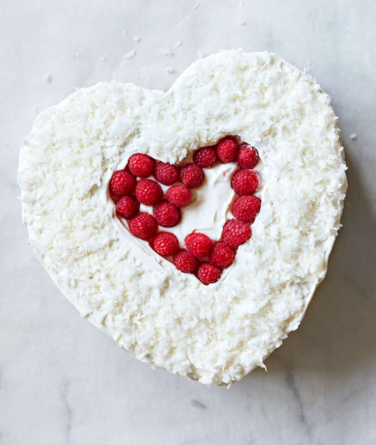 adding raspberry top layer to heart cake