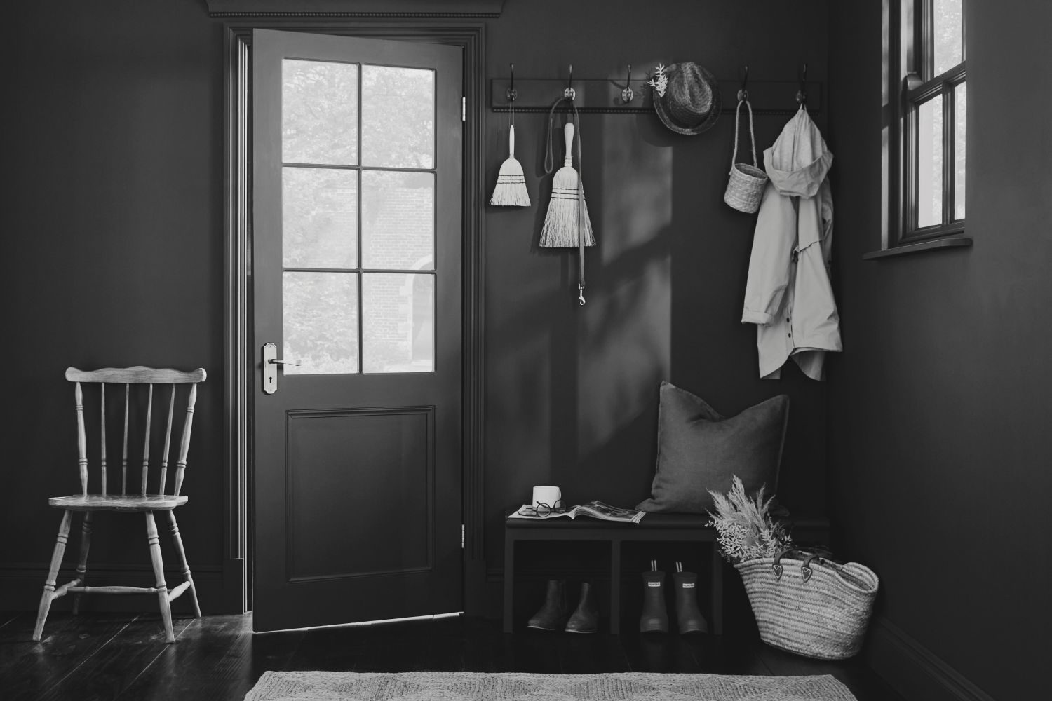 A tidy entryway with a bench coat hooks and a chair