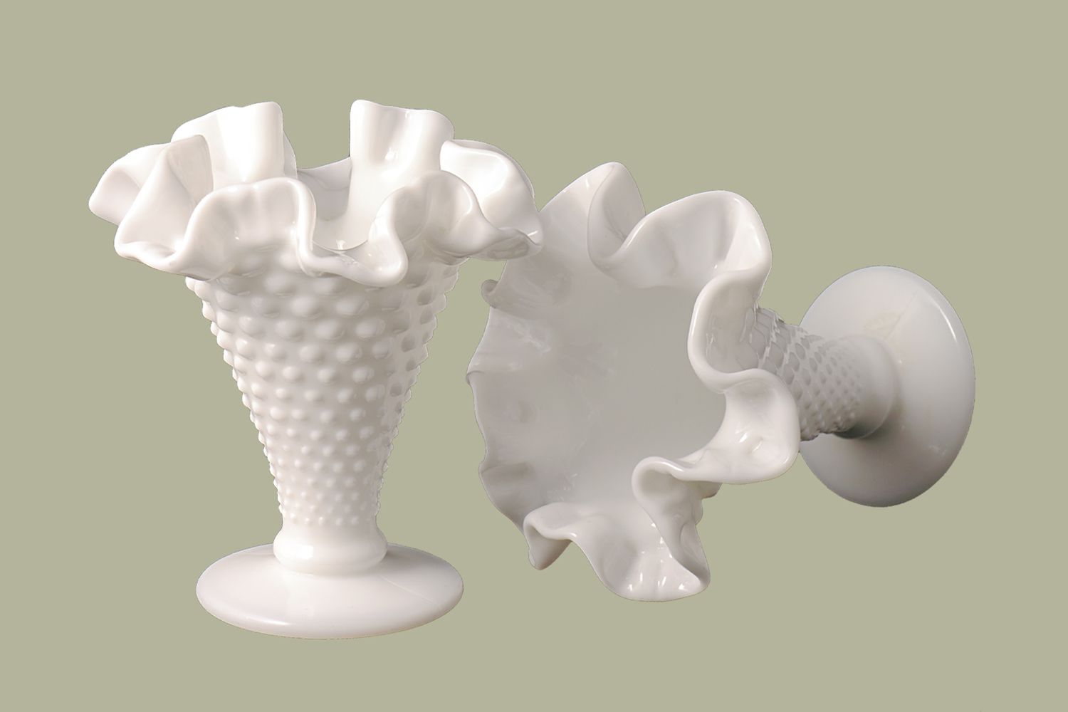 milk glass vases on green background