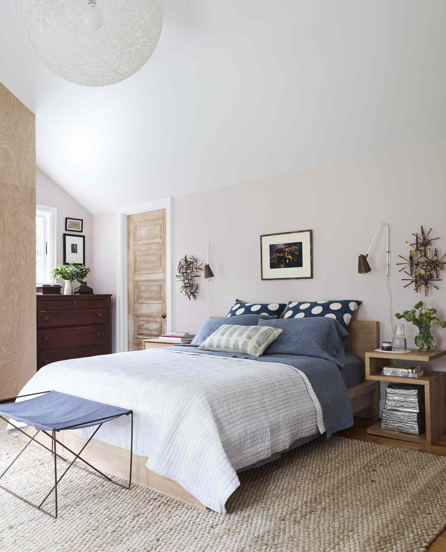 A cozy bedroom with a neatly made bed pillows and bedside tables