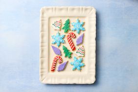 Tray of decorated sugar cookies in festive shapes like snowflakes candy canes and Christmas trees
