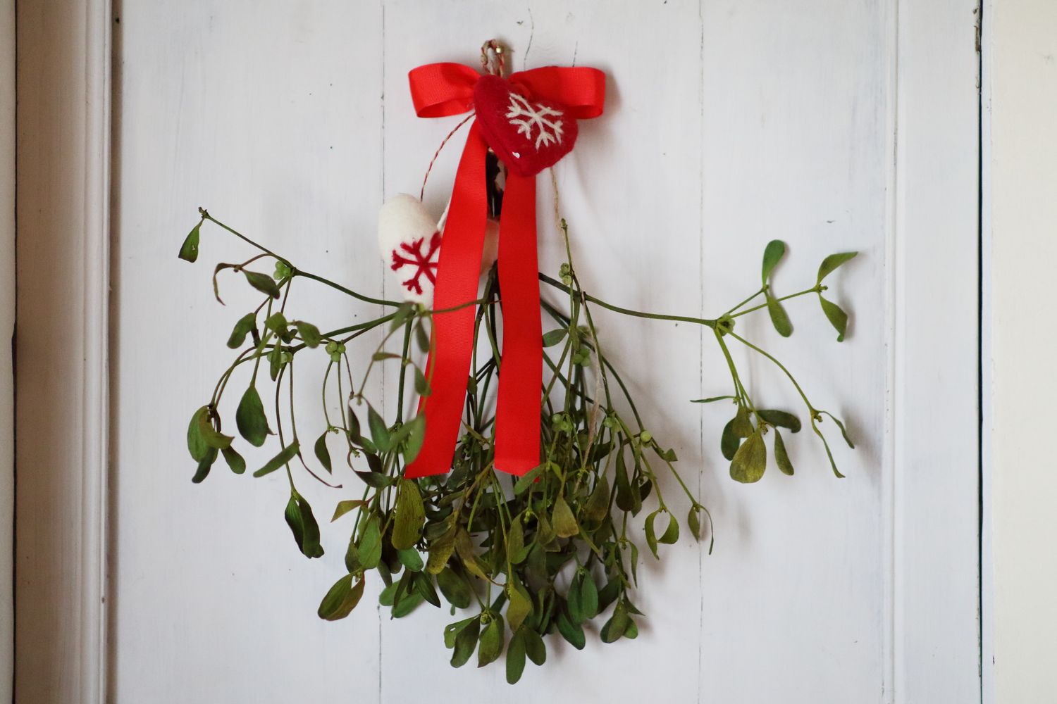 Hanging mistletoe adorned with decorative ribbons and ornaments