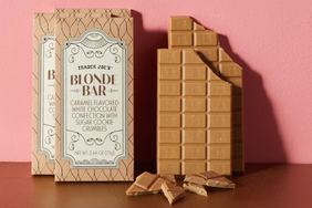 Two packages and a partially eaten bar of Trader Joes Blonde Bar a caramelflavored white chocolate confection with sugar cookie crumbles