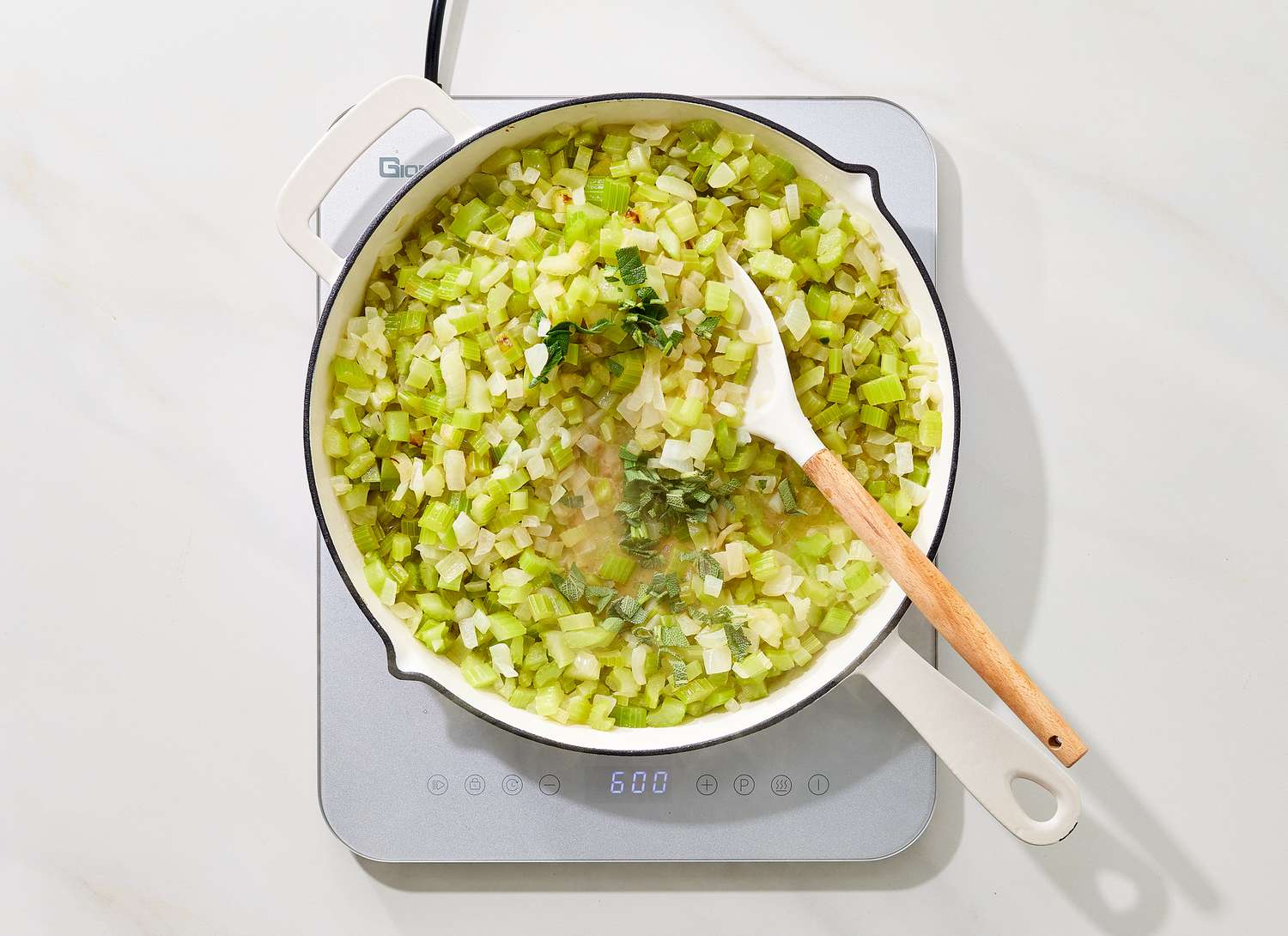 overhead view of celery and onions cooking in a pot