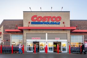 The entrance of a Costco Wholesale store with people entering and exiting