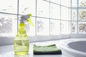 spray bottle and microfiber towel in front of windows