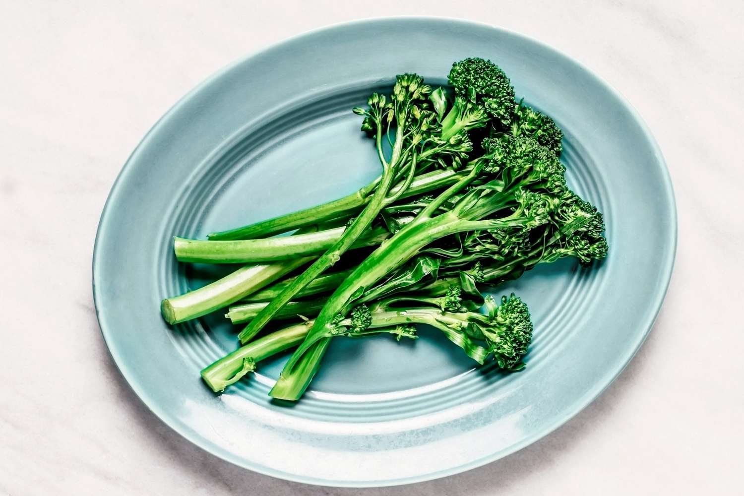 steam broccolini on blue blate