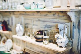 Shelving with various thrift store items like glassware and ornaments