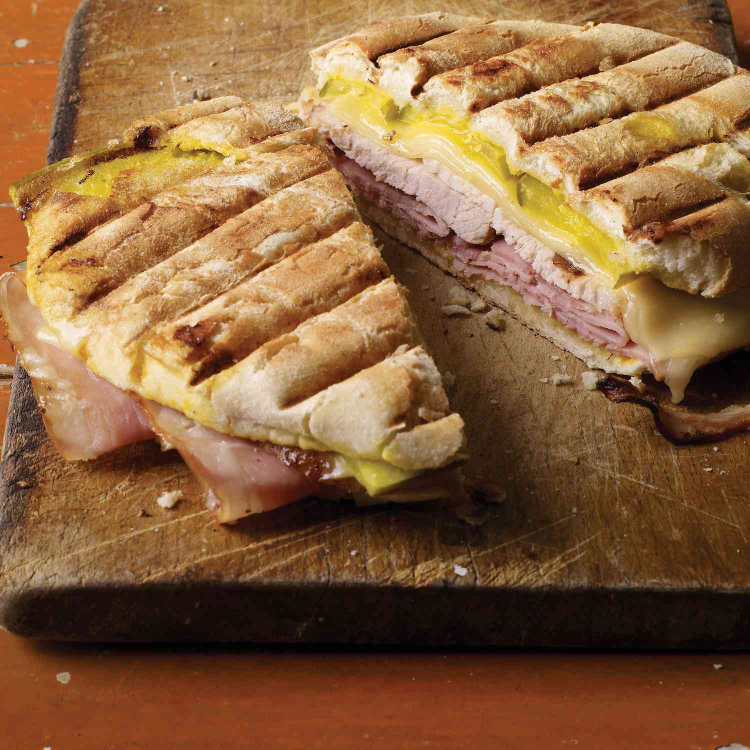 cubano sandwich sliced in half on wooden board