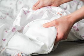Hands adjusting or holding bedding closeup view