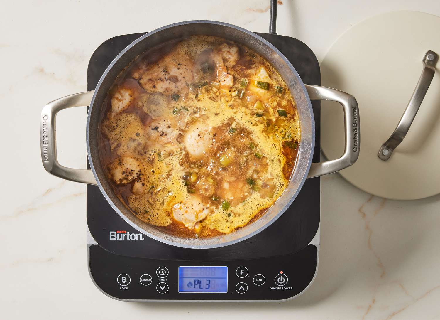 white chili simmering on a cooktop on marble surface