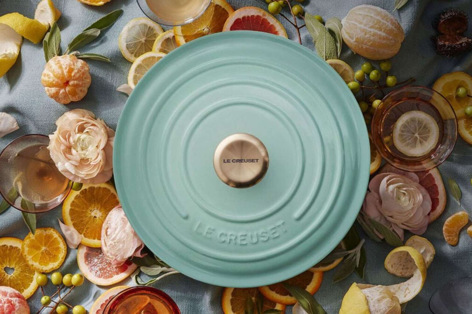 Le Creuset cookware lid surrounded by sliced citrus and flowers