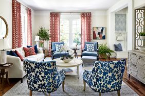 neutral-colored living room with blue chairs and red accent pieces