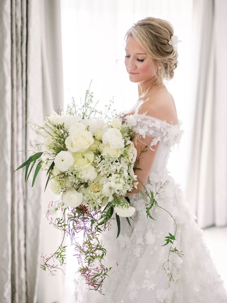Large white wedding bouquet with green foliage
