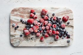 Frozen mixed berries displayed on a marble cutting board
