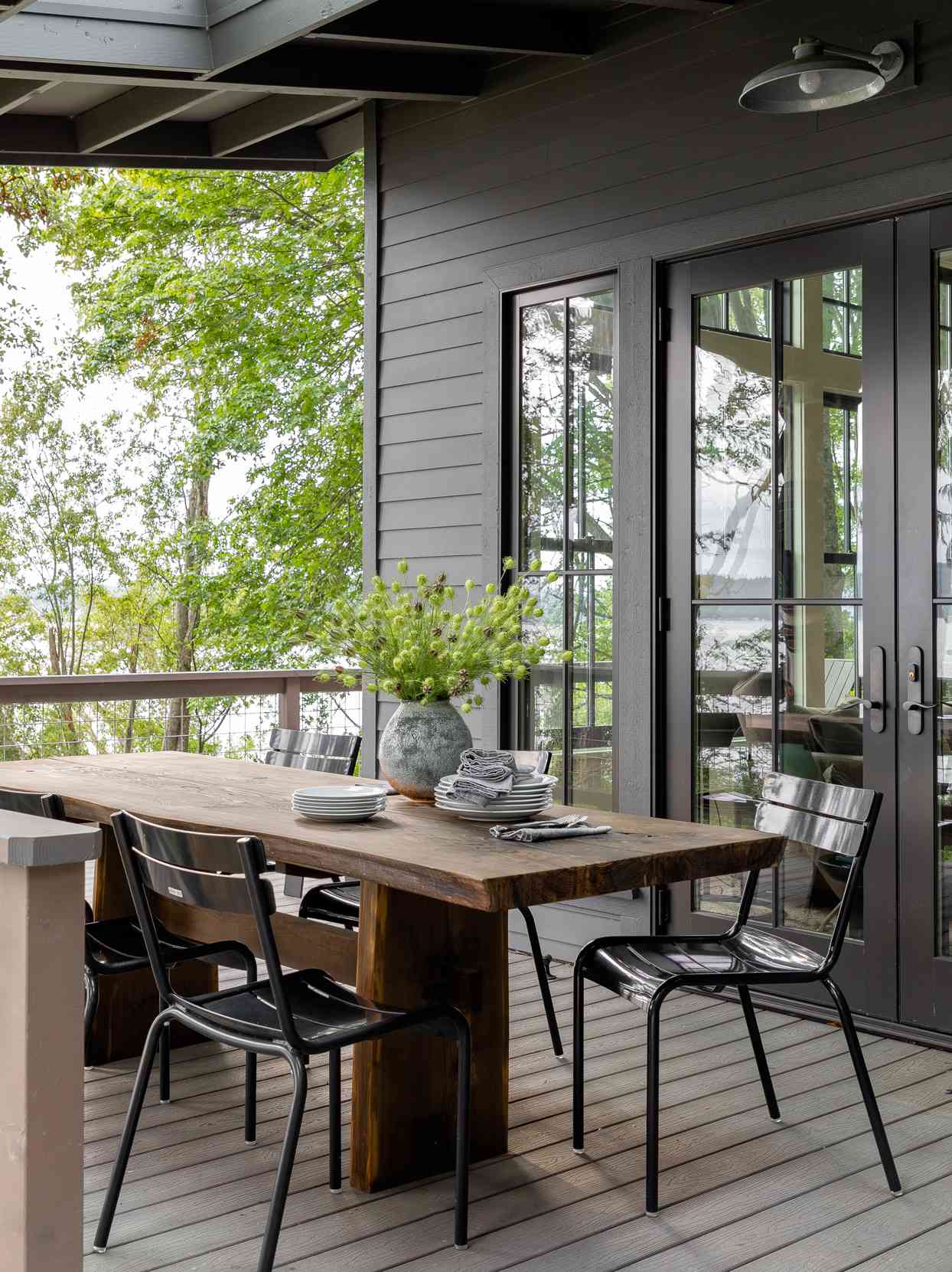 vase of green flowers atop outdoor dining table on deck