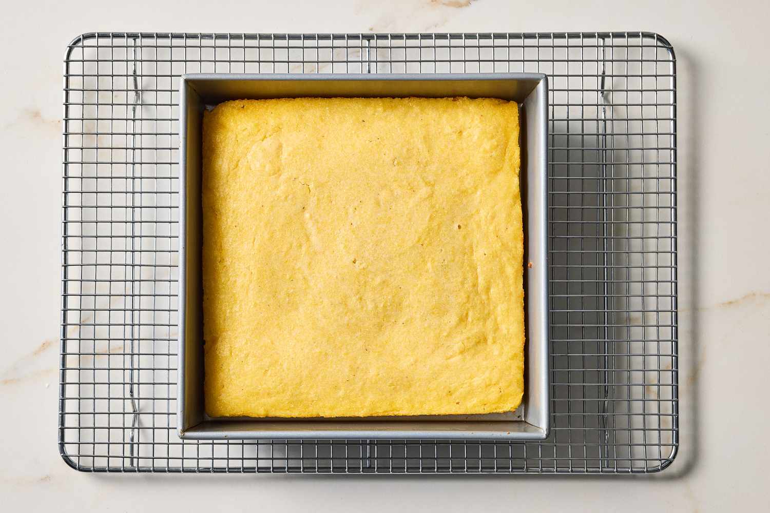 Square pan of baked buttermilk cornbread cooling on a wire rack