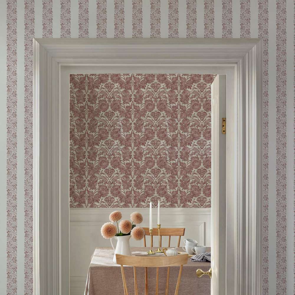 Interior view through open door showing patterned walls a dining setup with chairs and tableware visible