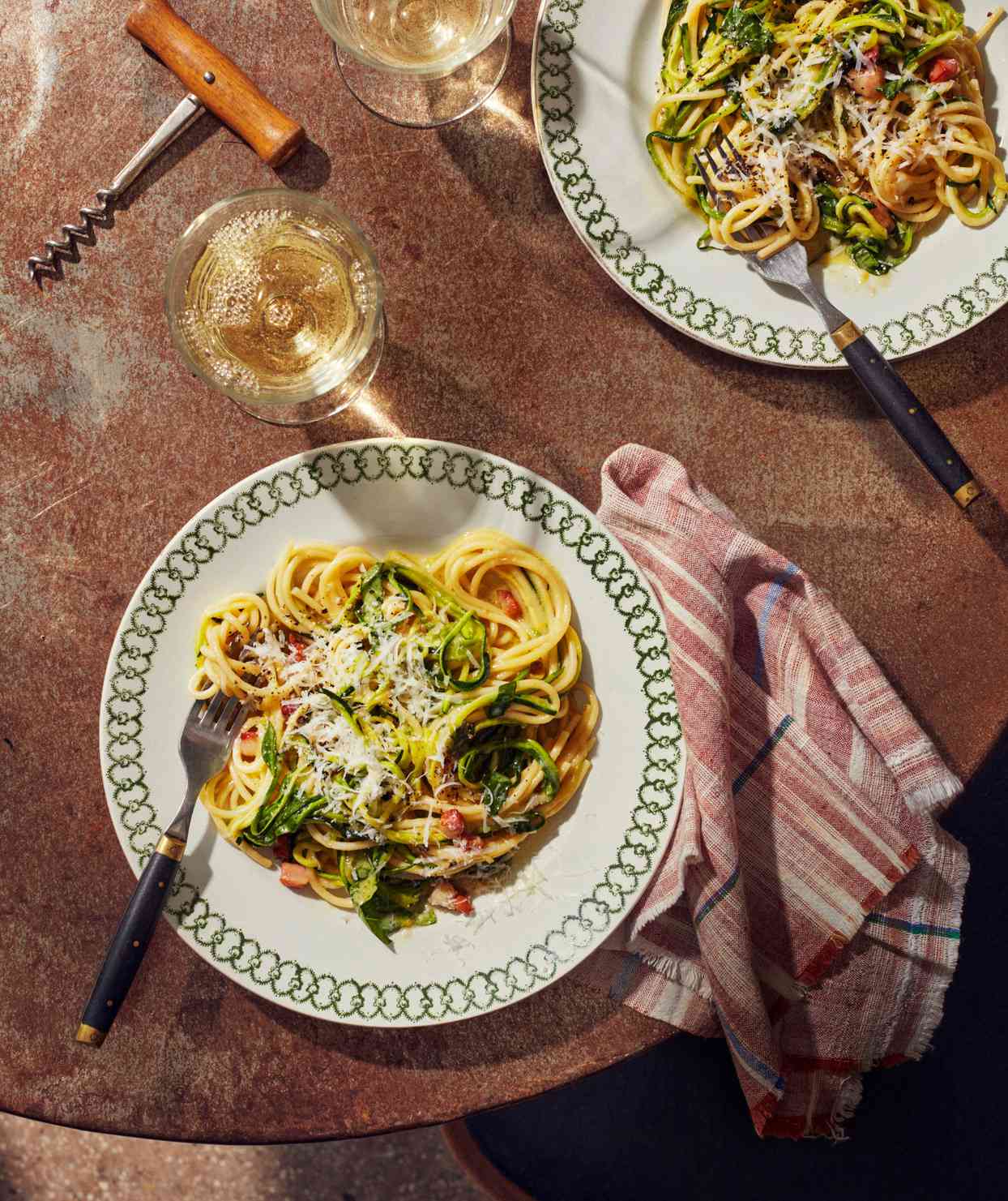 zucchini carbonara topped with fresh basil leaves