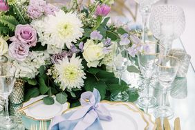 gold and white place settings with blue linens and floral centerpieces