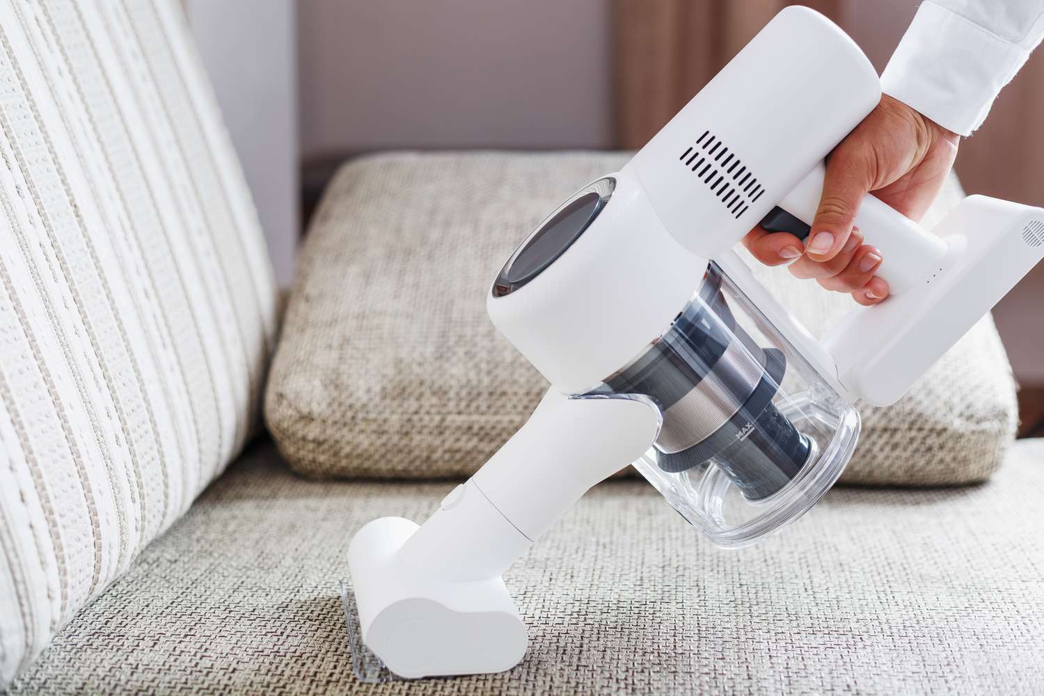 vacuuming sofa to remove odors