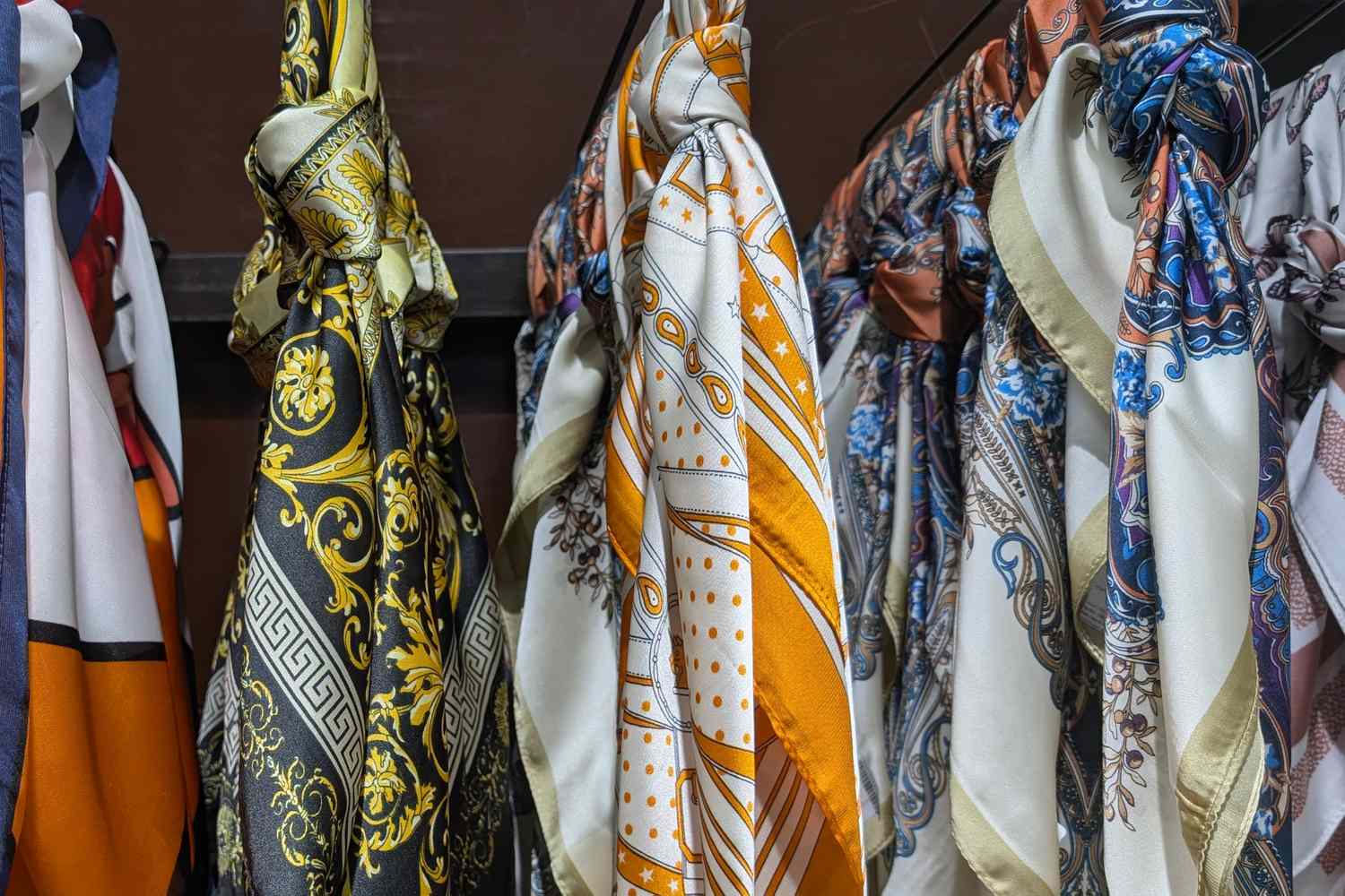 Various patterned silk scarves displayed on racks