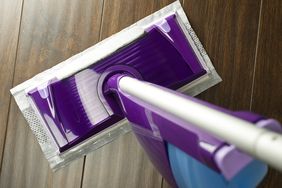 A cleaning mop with a disposable pad on a hardwood floor