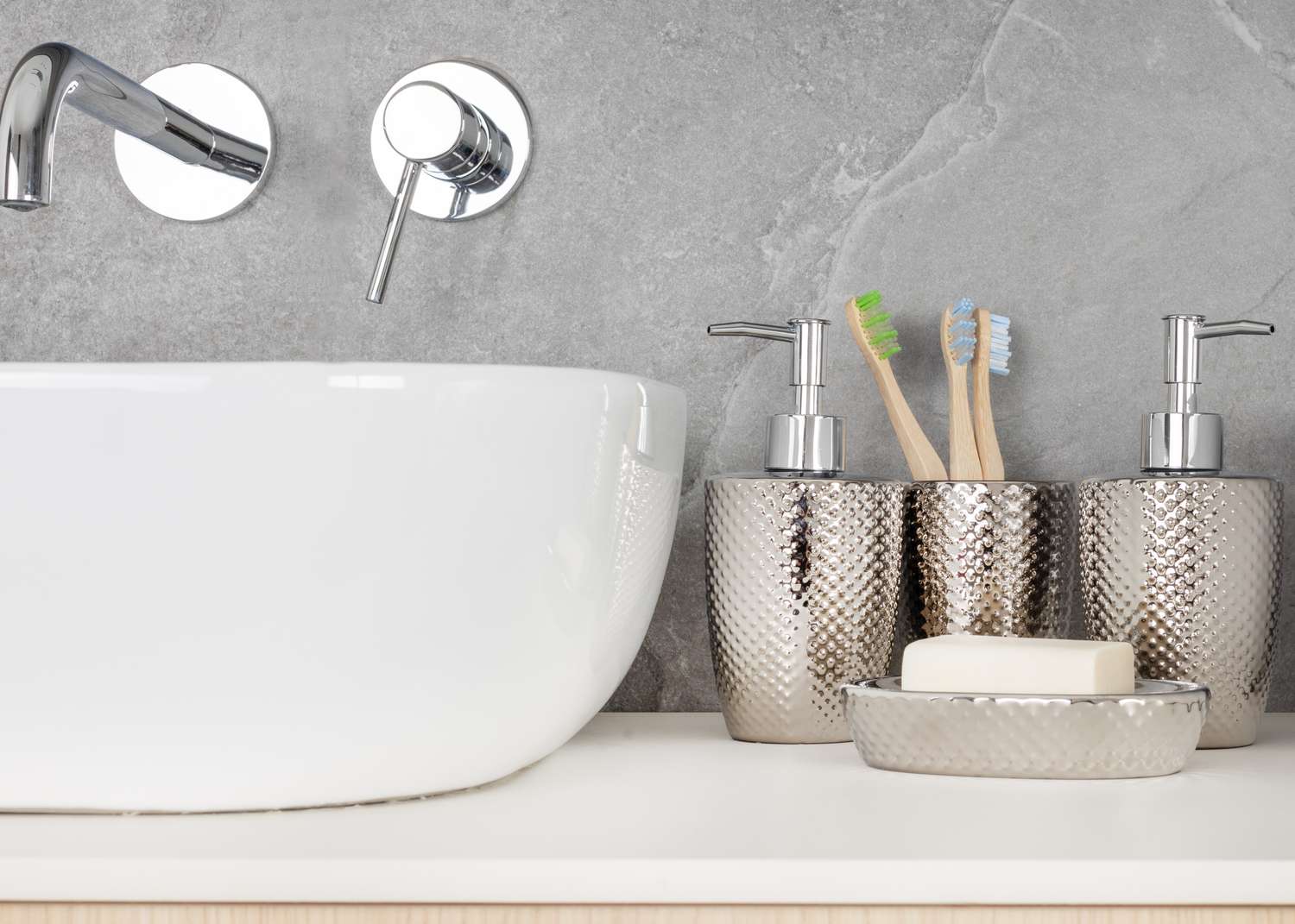 Sink area with soap dispenser toothbrush holder and bar soap placed on a counter