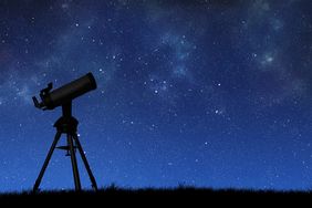 Telescope silhouette against the starry sky