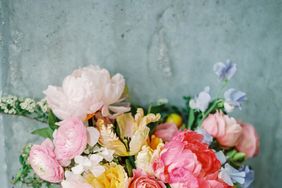 pink-and-white peony bouquet with blush ranunculus, yellow roses, and purple sweet peas
