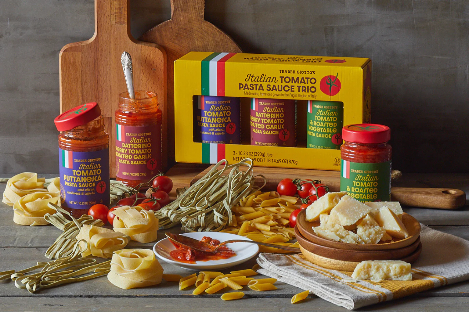 An assortment of Italian pasta sauces and ingredients including jars of sauce various pasta types cheese and tomatoes