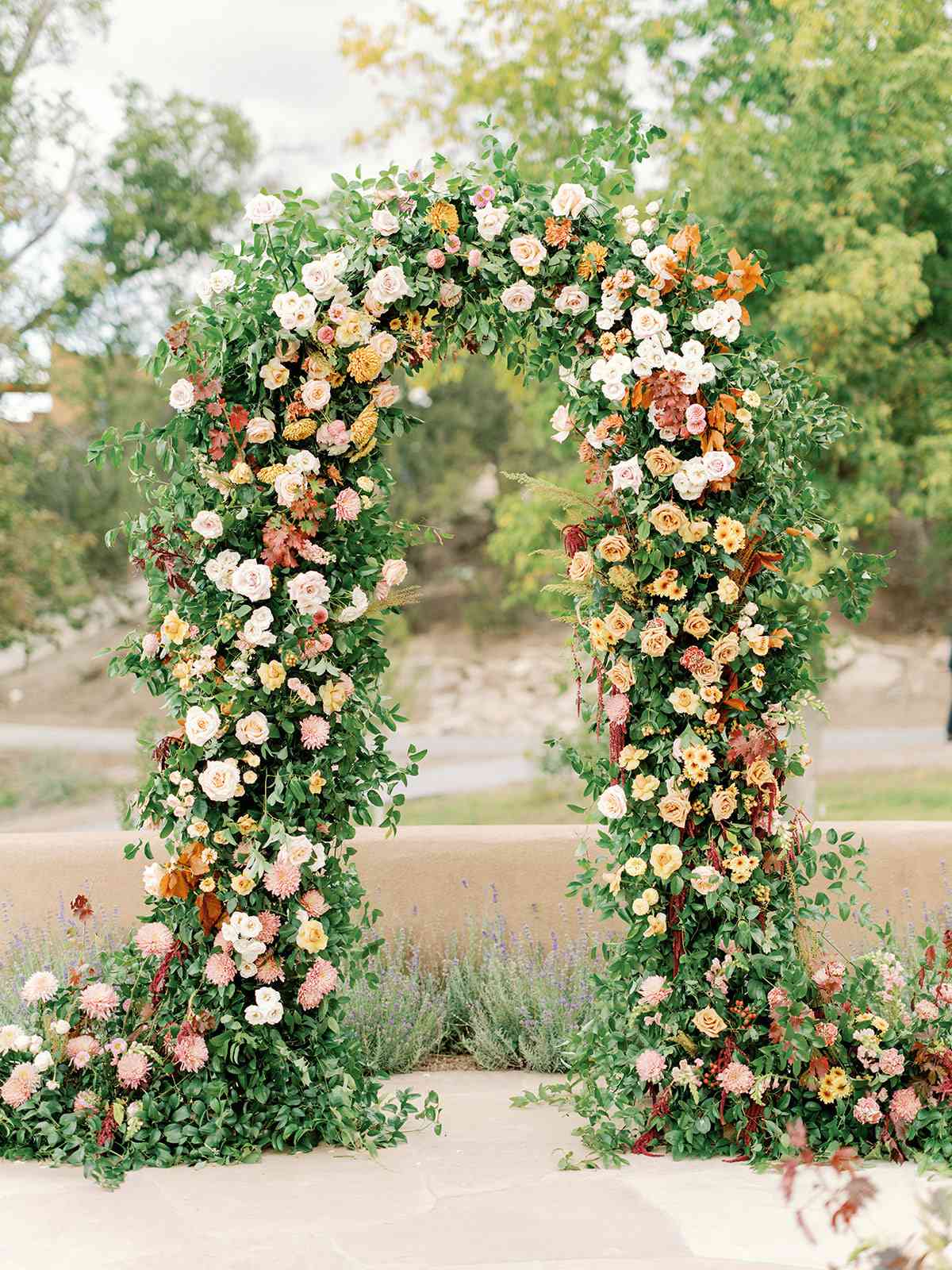 santa fe sunset inspired floral arch covered in pink and yellow flowers
