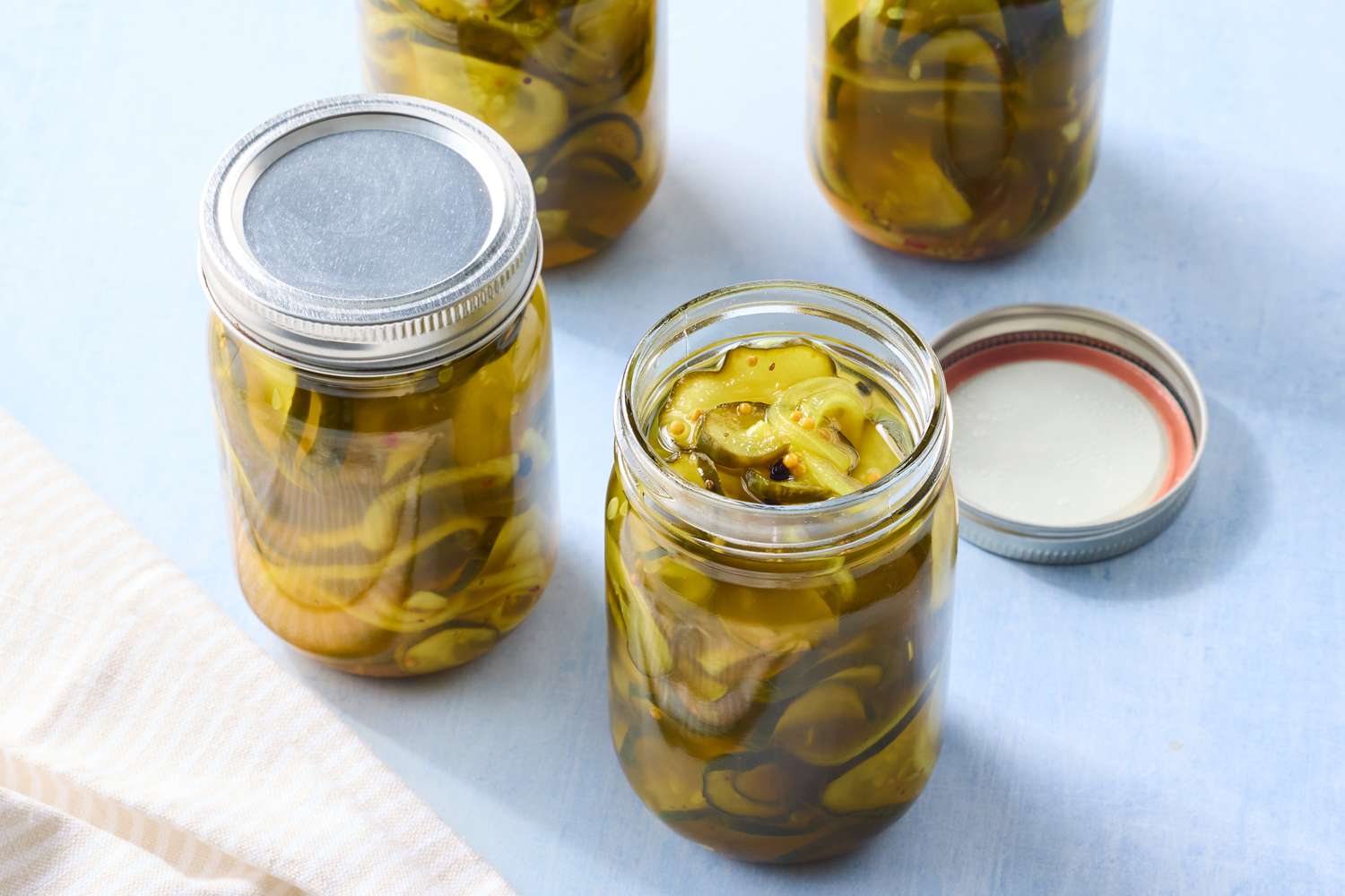 Jars of pickled vegetables on a surface one jar is open