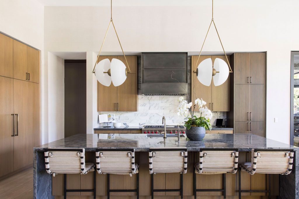 Kitchen with brown cabinets and dramatic pendant lights