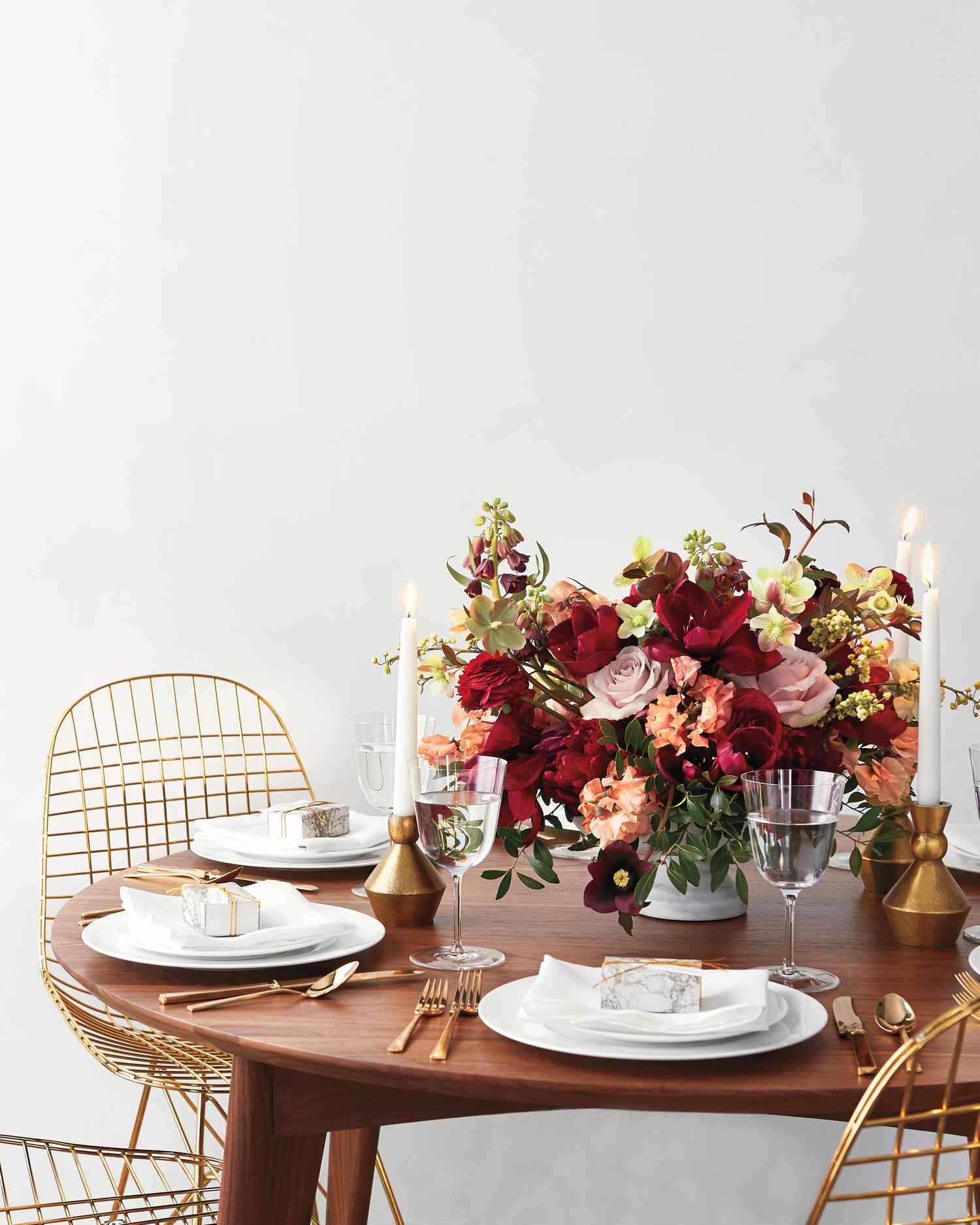 Gold tablesetting with white taper candles and floral centerpiece