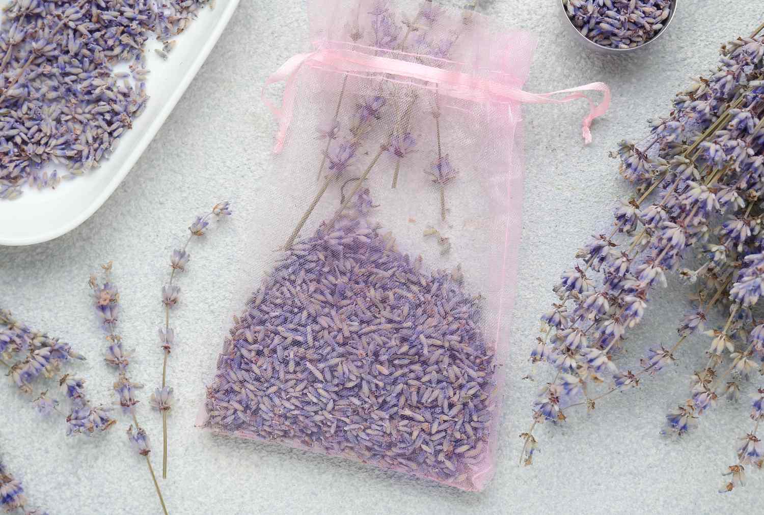 Lavender sachet with dried lavender sprigs and flowers surrounding it