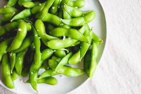 edamame pods sprinkled with salt on plate.