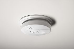 A smoke detector on the ceiling of a home.