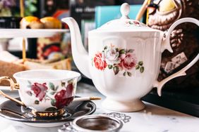 Ceramic teapot and teacup with floral designs on a table