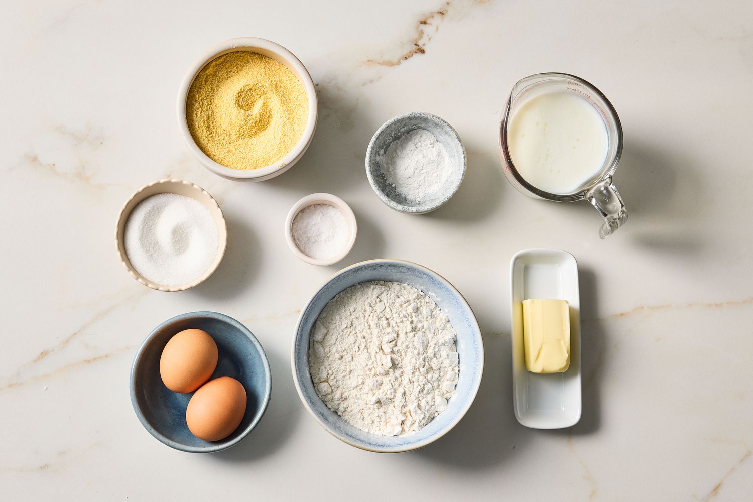 Ingredients for buttermilk cornbread including cornmeal flour milk eggs butter sugar salt and baking powder