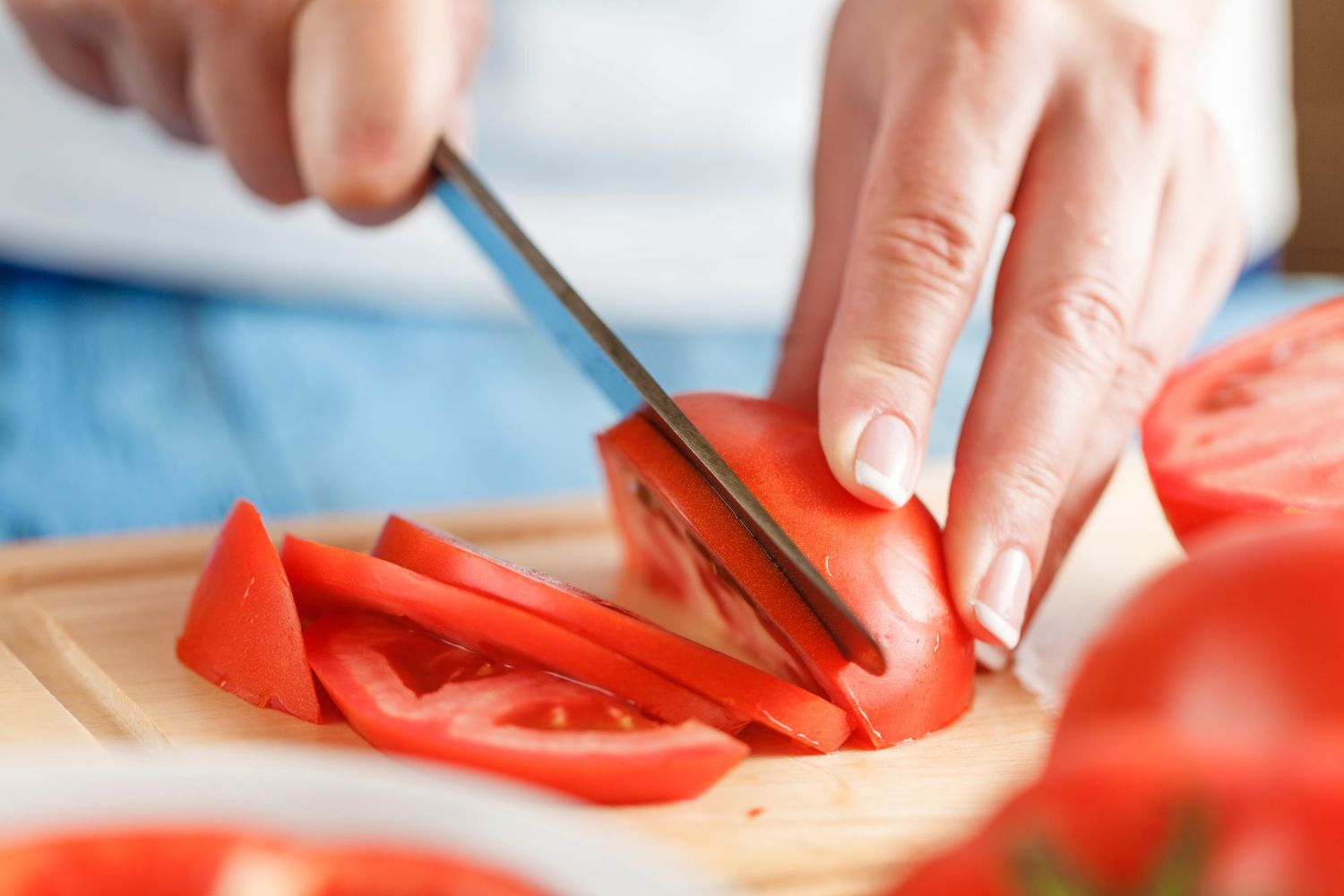 Slicing tomato on cutting board